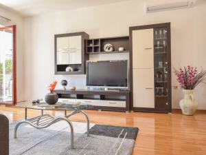 Apartment Aurora by Interhome في بوزت: غرفة معيشة مع تلفزيون وطاولة