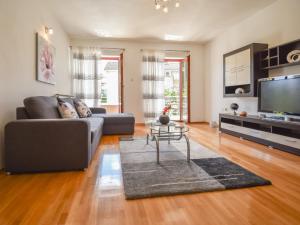 salon z kanapą i telewizorem w obiekcie Apartment Aurora by Interhome w mieście Buzet