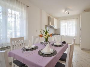 a dining room table with a purple table cloth at Apartment Aurora by Interhome in Buzet