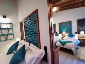 1 dormitorio con 2 camas y espejo en Village Hideaways & Spas, en Isla Fulhadhoo