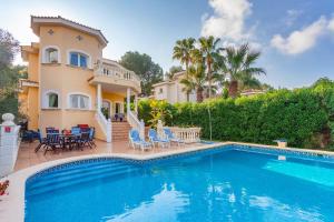 une villa avec une piscine en face d'une maison dans l'établissement Villa Margarita, à Costa de la Calma