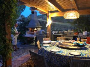 a table in a patio with a kitchen with a stove at Casale ristrutturato 3 Km Tropea in Santa Domenica