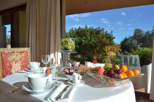 a table with a bowl of fruit on a white table cloth at Villa Zagara Luxury Bed And Breakfast in Pescara