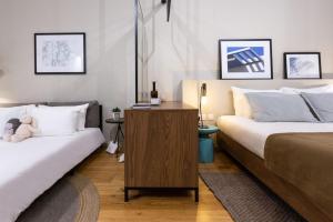 a bedroom with two beds and a wooden table at Guest House de la Valette in Valletta