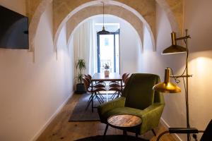 a living room with a green chair and a table at Guest House de la Valette in Valletta