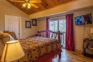 a bedroom with a bed and a tv and a window at Great View! Pool Table,Hot Tub,Privacy,Fireplace in Sevierville