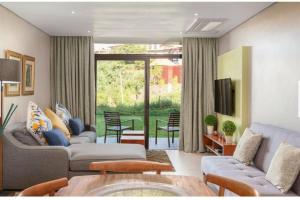 a living room with two couches and a table at Zimbali Suite 112 in Ballito