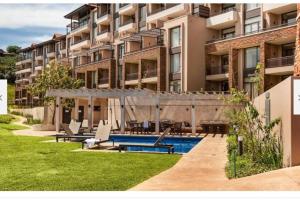a large apartment building with a swimming pool in a yard at Zimbali Suite 112 in Ballito