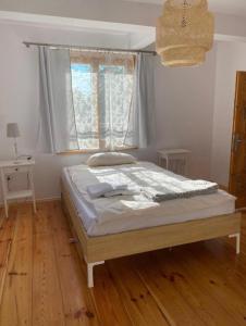 Łóżko w sypialni z drewnianą podłogą w obiekcie Moje Podlasie - Dom w Siemichoczach w mieście Siemiatycze