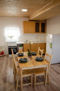 een keuken met een houten tafel met stoelen en een koelkast bij Apartmány PRO LIPNO in Horní Planá