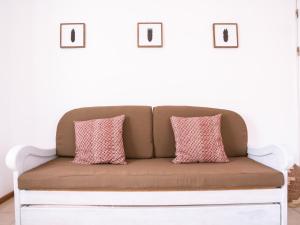 a couch with two pink pillows on top of it at Casa Blu Guesthouse - Maison d'hôtes in Santa Maria