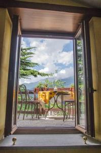widok na stół i krzesła przez przesuwne szklane drzwi w obiekcie Hotel Chez Toi w mieście Oulx