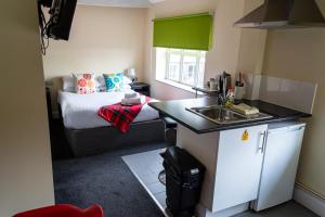 a small kitchen with a sink and a bed at Potbank in Stoke on Trent