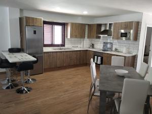 a kitchen with wooden cabinets and a table and chairs at Punta Negra in Puerto de Santiago