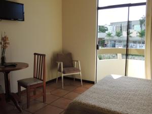 a room with a bed and a table and chairs at Hotel Beira Rio in Brusque +21 photos