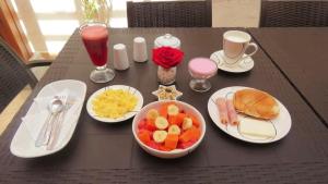 einen Tisch mit Teller mit Lebensmitteln und eine Schale mit Obst in der Unterkunft Hotel Tababela Land in Tababela