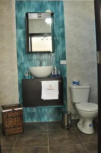 a bathroom with a sink and a toilet and a mirror at Hotel Tababela Land in Tababela