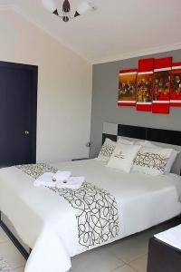 a bedroom with two beds with white sheets at Hotel Tababela Land in Tababela