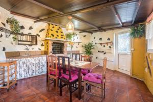 uma cozinha com uma mesa de madeira e cadeiras em Finca Alejandrina em La Guancha