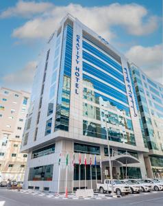 un edificio alto con coches estacionados frente a él en Gravity Hotel Abu Dhabi, en Abu Dabi