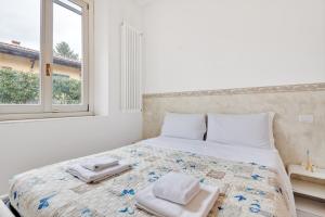 Un dormitorio blanco con una cama con toallas. en Coverciano Modern Apartment with Patio! en Florencia