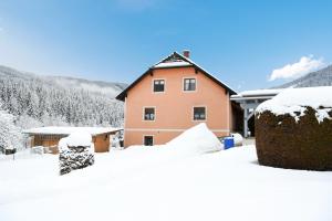 une maison recouverte de neige devant dans l'établissement Ferienwohnung Moser, à Sankt Blasen