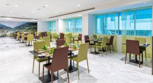 a restaurant with tables and chairs and windows at Gravity Hotel Abu Dhabi in Abu Dhabi