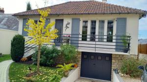 Una casa con una puerta de garaje negra y un árbol. en Croix Montoire, en Tours