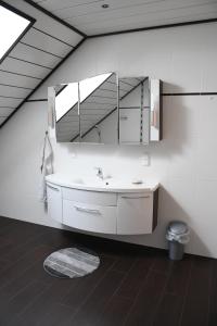 La salle de bains est pourvue d'un lavabo blanc et d'un miroir. dans l'établissement Ferienwohnung Moser, à Sankt Blasen