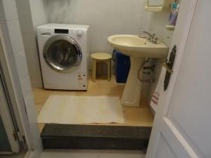 y baño con lavadora y lavamanos. en Casa Malvasia, en Lipari