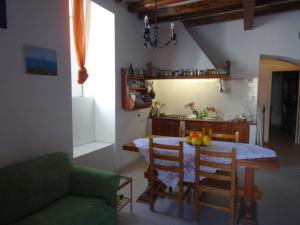 una cocina con mesa y sillas y una habitación con mesa y sofá. en Casa Malvasia, en Lipari