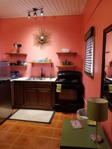 a kitchen with orange walls and a sink and a stove at St John Inn in Contant