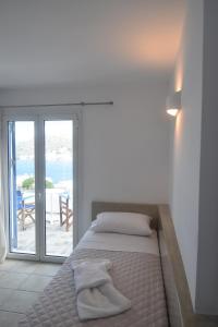 a bedroom with a bed with a view of the ocean at Pension The Big Blue in Katapola