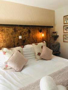 a bed with white sheets and pillows on it at Orchard House in Rosedale Abbey