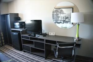 a desk with a television and a lamp and a mirror at Super 8 by Wyndham Spirit Lake/Okoboji in Spirit Lake