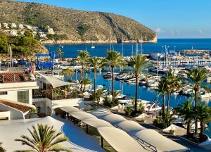 a view of a marina with boats and palm trees at Casa Calma Moraira in Moraira