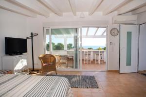 a bedroom with a bed and a television and a dining room at Casa Calma Moraira in Moraira