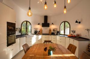 a large kitchen with a wooden table and a dining room at Casa Calma Moraira in Moraira