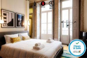 una camera da letto con un grande letto con asciugamani di NorteSoul Mouzinho a Porto