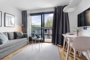 a living room with a couch and a table at HOOM Home & Hotel Sollentuna in Sollentuna