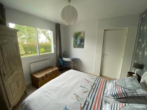 een slaapkamer met een bed en een raam bij Villa Aiguemarine in La Baule