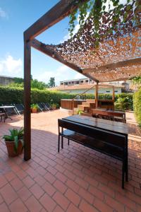 un banc assis sous une pergola sur une terrasse dans l'établissement Hotel Alto San Isidro, à San Isidro