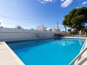 a large blue swimming pool with a white fence at INNOUTHOME Gran casa y piscina torrente in L'Ametlla de Mar