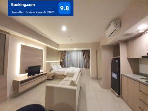 a living room with a couch and a tv in it at Apartemen Grand Kamala Lagoon Studio By Bonzela Property in Bekasi