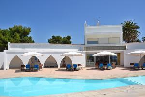 a resort with a swimming pool and chairs and umbrellas at Casa Três Palmeiras in Portimão