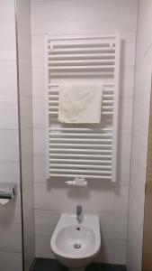 La salle de bains blanche est pourvue d'un lavabo et d'une serviette. dans l'établissement Residence Condor, à Maranza