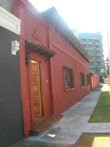 un edificio rosso con una porta rossa su una strada di Iquique Beachfront a Iquique