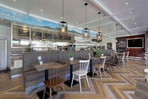 a restaurant with a bar with tables and chairs at Christiansen im Panoramahaus Duhnen in Cuxhaven