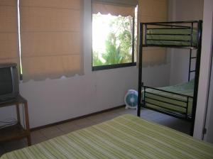 een slaapkamer met 2 stapelbedden en een televisie bij Iquique Beachfront in Iquique