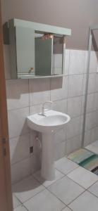 a bathroom with a white sink and a mirror at JOÃO CARLOS CASAS 3 Quartos Penha SC in Penha +16 photos